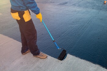 Roofer applying roof coating in North Delran, NJ